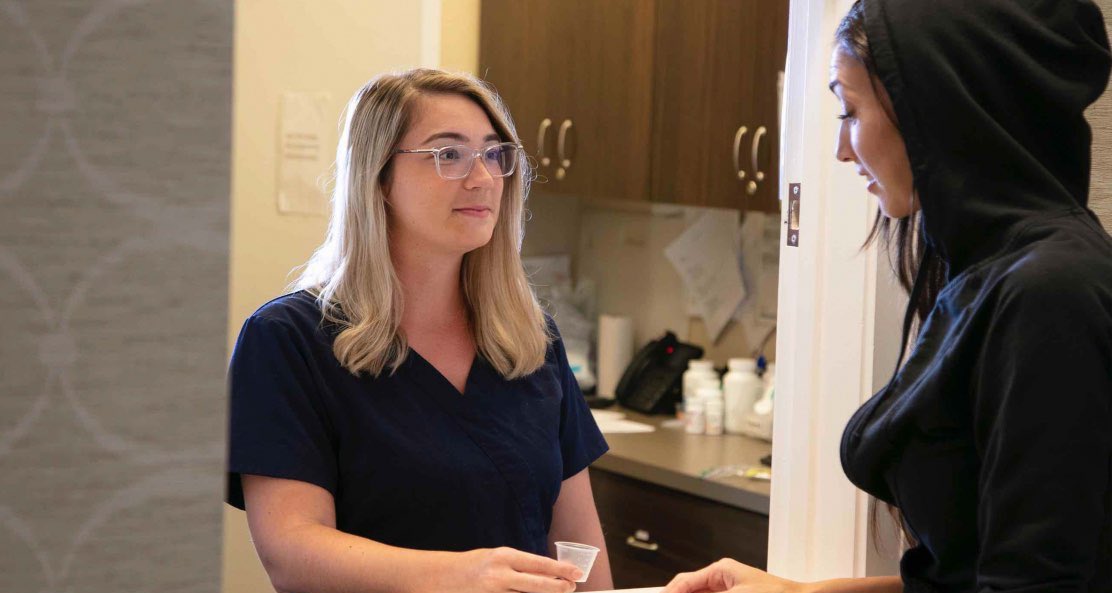 Two ladies partake in a intense dialogue about the diverse drug and alcohol intervention approaches, including the Johnson Model, Invitational Model, Systemic Family Model, ARISE Model, Motivational Interviewing, CRAFT, and the Field Model, emphasizing their individual approaches to recovery.