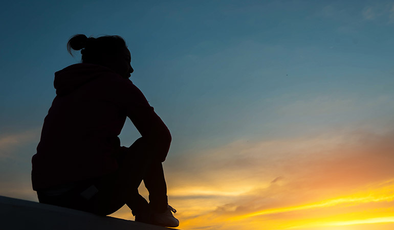 a young woman gazing at the sunset