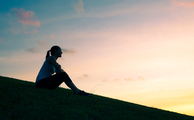 woman watching the sunset on a hill